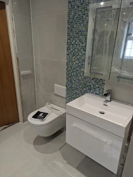 Blue mosaic tile bathroom with white vanity unit