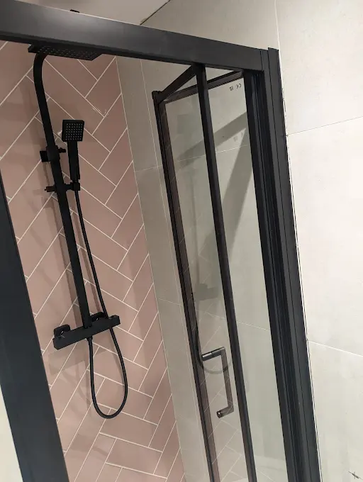 Pink herringbone statement tiles in a modern shower