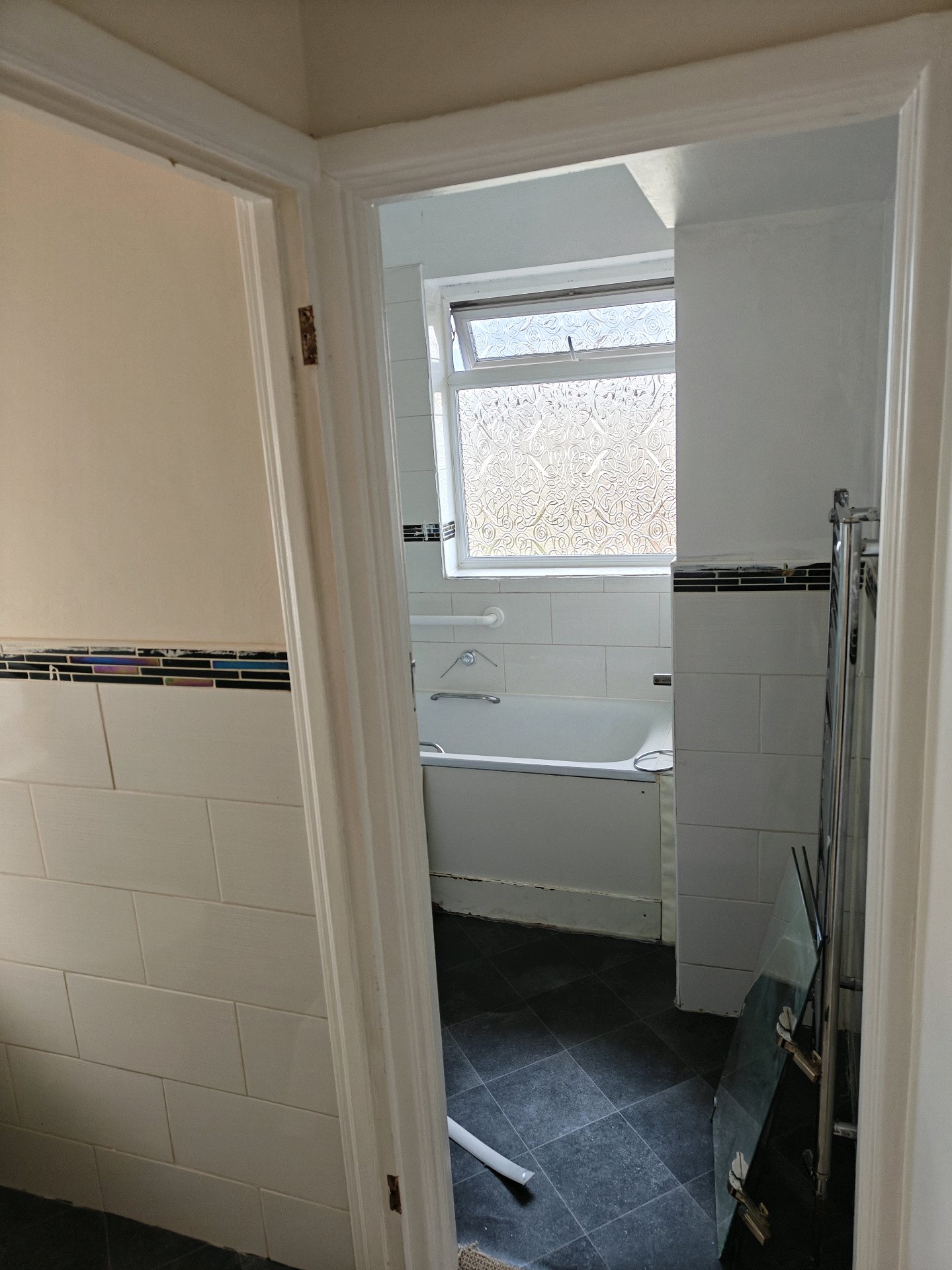 Before: Old bathroom through doorway showing dated fixtures