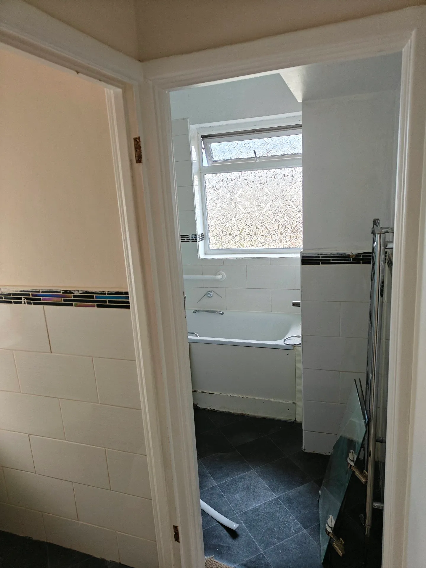 Before: the same dated bathroom seen through the doorway, prior to renovation