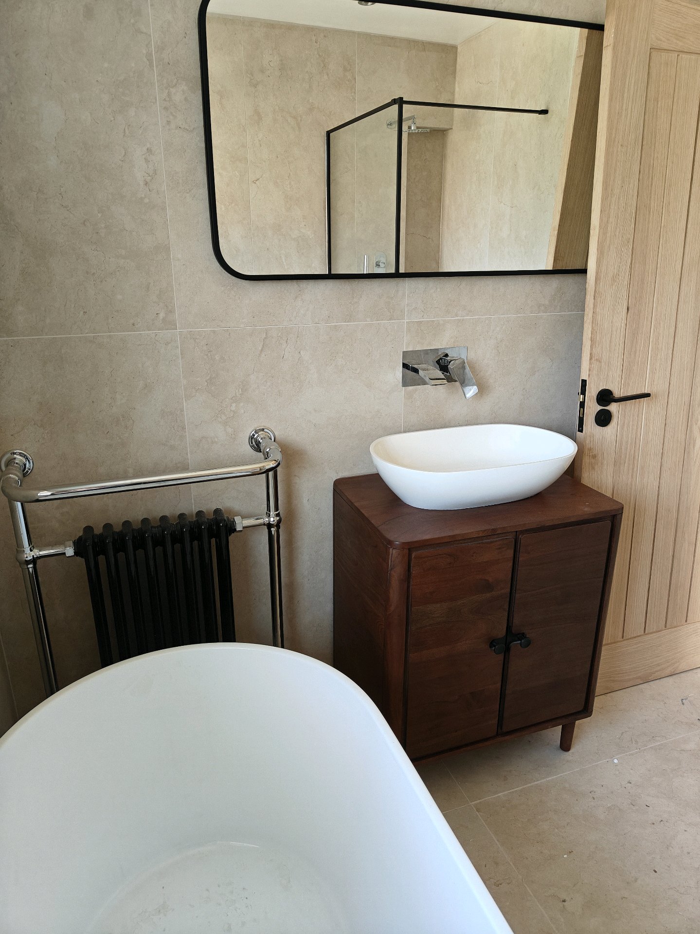 Floating wooden vanity unit with brass fixtures installed by GWS Plumbing